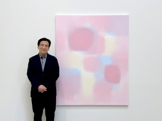 서승원 화백이 PKM갤러리에서 개막한 개인전 ‘인터플레이’에 전시된 자신의 작품 앞에서 포즈를 취하고 있다. 사진 제공=PKM갤러리