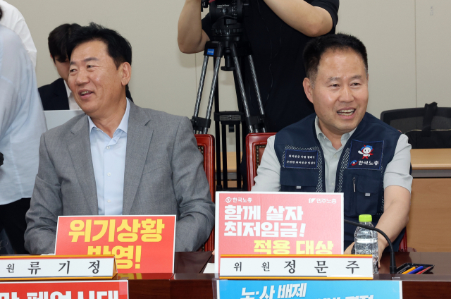 최저임금위원회 사용자위원인 류기정(왼쪽) 한국경영자총협회 전무와 근로자위원인 정문주 한국노총 중앙연구원장이 10일 정부세종청사에서 열린 최저임금위원회 제4차 전원회의에서 나란히 앉아 웃음 짓고 있다. 연합뉴스