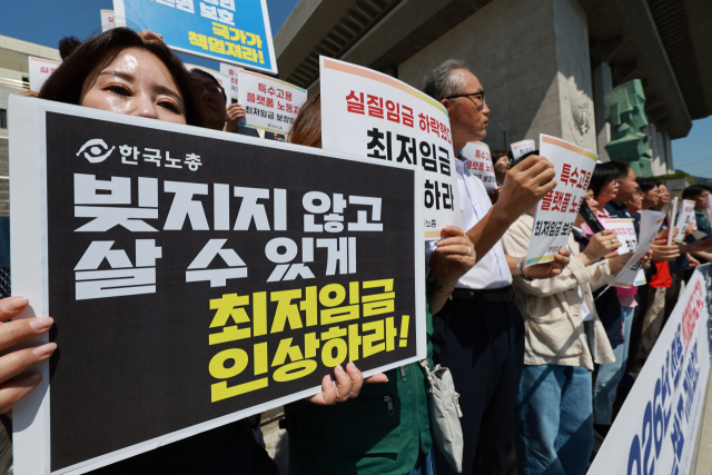 양대 노총 조합원들이 11일 서울 종로구 세종문화회관 계단에서 내년에 적용할 최저임금 요구안을 발표하고 있다. 연합뉴스