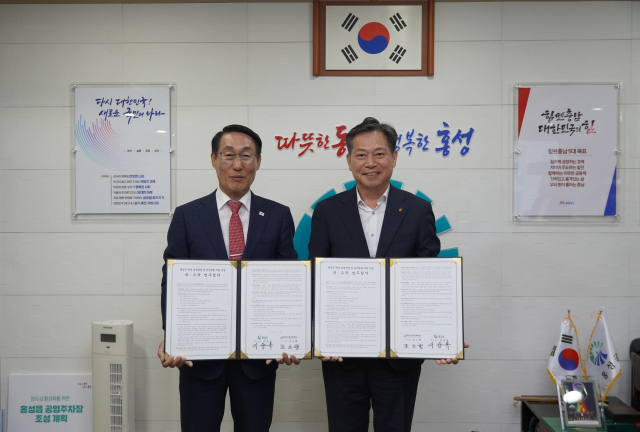 조소행(오른쪽) 충남신용보증재단 이사장과 이용록(왼쪽) 홍성군수가 업무협약을 체결하고 기념촬영을 하고 있다. 사진제공=충남신용보증재단