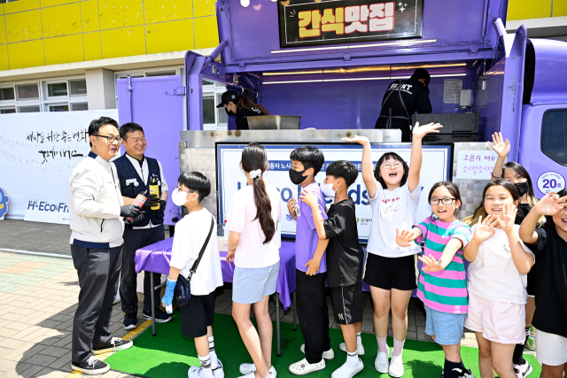현대차 노사는 11일 울산 북구 양정초등학교에서 학생 대상으로 ‘H-Eco Friends 친환경 물품 구입’을 위한 사회공헌기금 1억 원을 굿네이버스에 전달한 뒤, 양정초 아이들에게 친환경 유기농 3종 간식, 업사이클링 양말, 우산 등과 함께 간식차도 지원했다. 사진제공=현대자동차