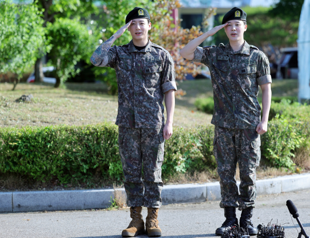 육군 병장으로 만기 전역한 BTS 지민과 정국이 11일 경기 연천군 연천공설운동장에서 열린 기념행사에서 팬들에게 거수경례로 전역 인사하고 있다. 연합뉴스