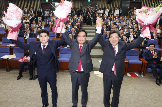 송언석(가운데) 국민의힘 의원이 16일 국회에서 열린 원내대표 선출 의원총회에서 원내대표로 선출된 뒤 김용태(왼쪽) 비상대책위원장, 권성동 전 원내대표와 손을 맞잡아 들고 있다. 오승현 기자