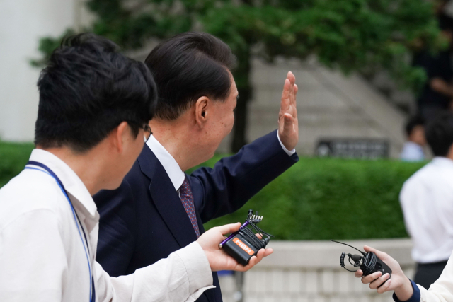 윤석열 전 대통령이 16일 서울 서초구 서울중앙지방법원에서 열린 내란 우두머리 혐의·직권남용 권리행사 방해 혐의 사건 7차 공판을 마치고 법원을 나서며 지지자들을 향해 인사하고 있다. 연합뉴스