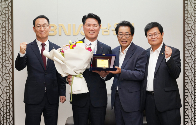 김태한(왼쪽 두 번째) BNK경남은행 은행장이 17일 경상남도육상연맹 회장 당선패를 전달받고 있다. 사진 제공=BNK경남은행