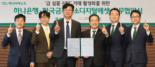 이호성(오른쪽) 하나은행장이 강진모 아이티센글로벌 회장과 금 실물 신탁 거래를 위한 업무협약서를 17일 들어 보이고 있다. 사진 제공=하나은행