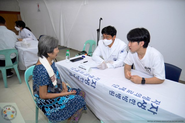 신민식(가운데) 자생의료재단 사회공헌위원장이 필리핀 한국전 참전용사 가족을 진료하고 있다. 사진 제공=자생의료재단