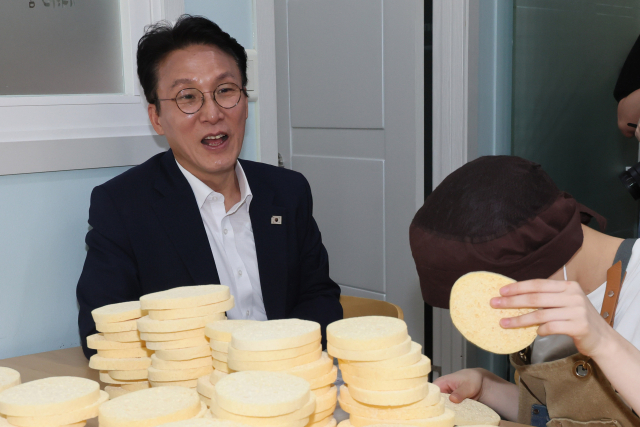 국회 인사청문회를 앞두고 있는 김민석(왼쪽) 국무총리 후보자가 19일 발달장애인 일자리 현장 간담회를 열기 위해 방문한 서울 영등포구의 한 사회적협동조합에서 작업 현장을 둘러보고 있다. 연합뉴스