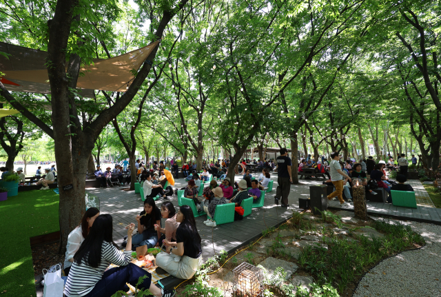 지난달 22일 서울 동작구 보라매공원에서 열린 2025 서울국제정원박람회를 찾은 시민들이 점심시간을 맞아 산책과 나들이를 즐기고 있다. 연합뉴스