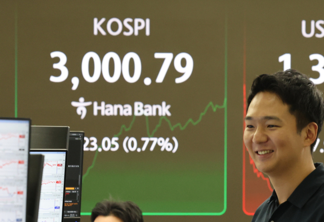 코스피지수가 장중 3000을 돌파한 20일 서울 중구 하나은행 딜링룸에서 딜러들이 대화하고 있다. 연합뉴스