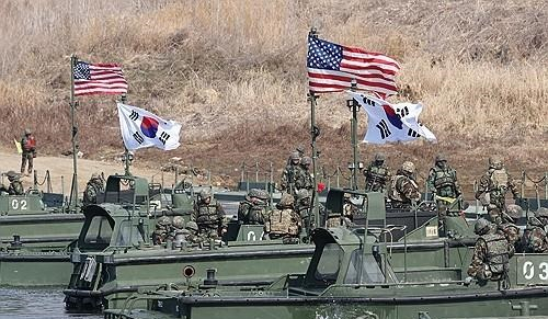 경기도 연천군에서 실시된 한미 연합 제병 협동 도하 훈련에서 한미 장병이 태극기와 성조기 아래 부교를 연결하고 있다. 연합뉴스