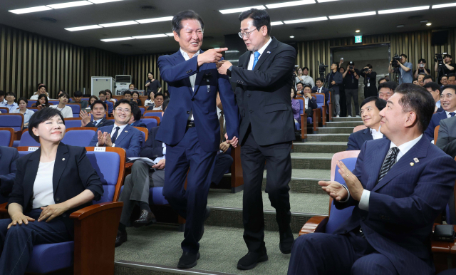 당 대표 선거 출마를 선언한 정청래(왼쪽)·박찬대 더불어민주당 의원이 24일 국회에서 열린 의원총회에 손을 잡고 참석하고 있다. 오승현 기자 2025.06.24