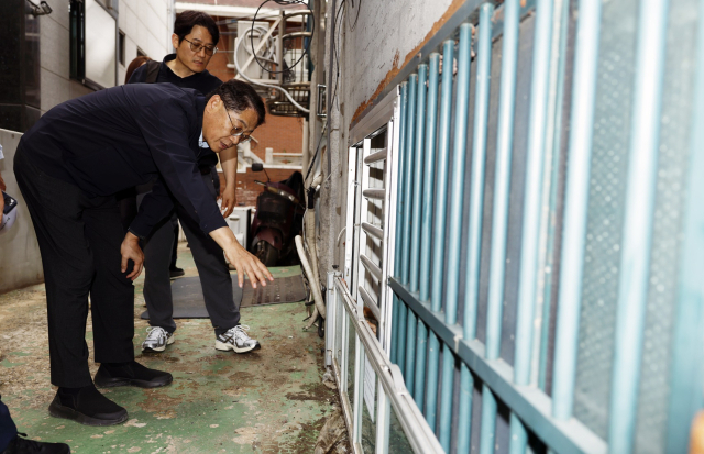 황상하 SH공사 사장이 24일 서울 관악구 신림동 일대 반지하 주택에 설치된 차수판과 개폐형 방범창이 제대로 작동하는지 살펴보고 있다. 사진 제공=SH공사