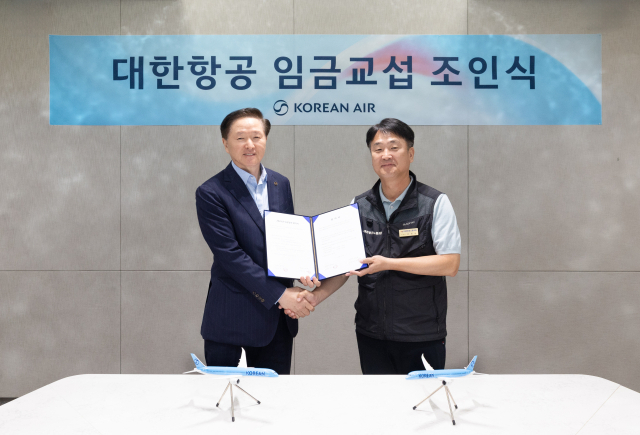 우기홍(왼쪽) 대한항공 부회장과 조영남 대한항공 노동조합위원장이 26일 서울 강서구 대한항공 본사에서 열린 ‘2025년 임금교섭 조인식’에서 기념 사진을 촬영하고 있다. 사진 제공=대한항공