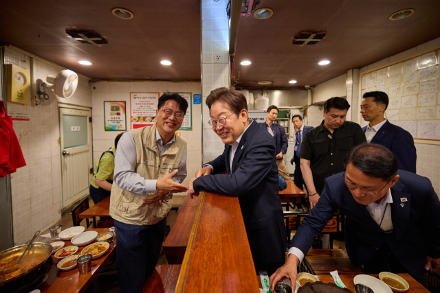 이재명 대통령이 26일 점심 식사를 위해 방문한 서울 용산 대통령실 인근 한 식당에서 시민과 대화하고 있다. 연합뉴스