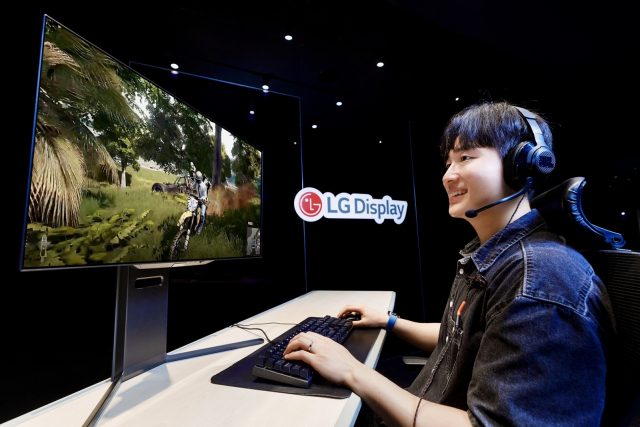 LG디스플레이 모델이 4세대 27인치 유기발광다이오드(OLED) 모니터용 패널이 적용된 모니터로 게임을 즐기고 있다. 사진=LG디스플레이