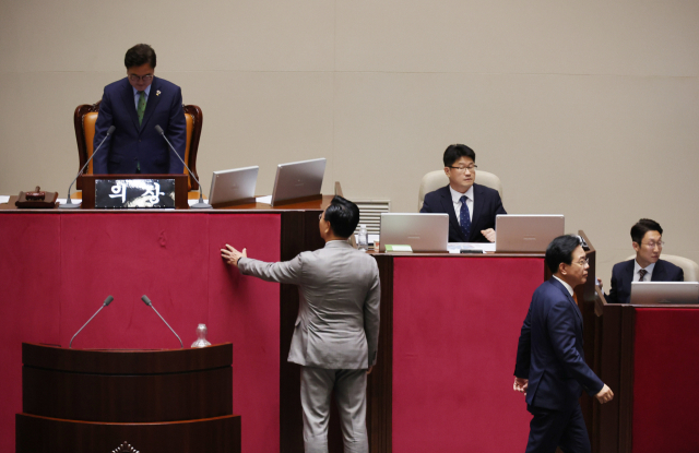 여당인 더불어민주당의 일방적 요청으로 27일 국회 본회의가 열려 법사위원장 선출 안건 등이 강행 처리되려 하자 송언석(앞줄 오른쪽) 국민의힘 원내대표가 우원식(뒷줄 왼쪽) 국회의장에게 항의하다가 퇴장하고 있다. 연합뉴스