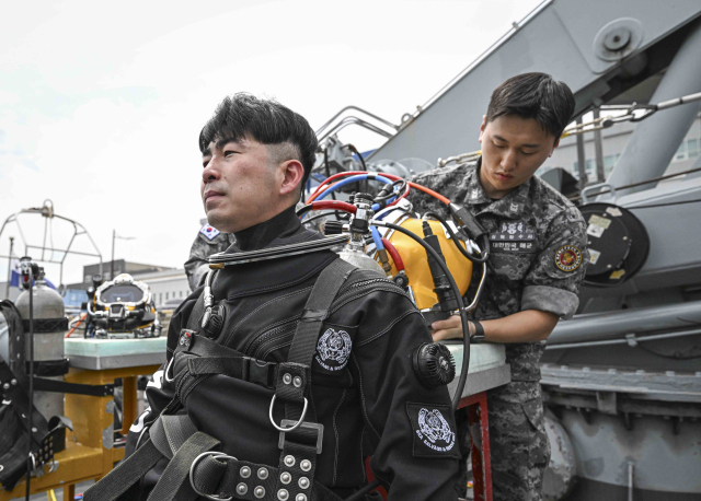 12일 경남 진해 해군기지 내 해군해난구조전대(SSU)에서 이현호 서울경제신문 기자가 드라이 잠수복을 착용하며 수중 잠수 훈련 과정을 체험하고 있다. 사진 제공=해군