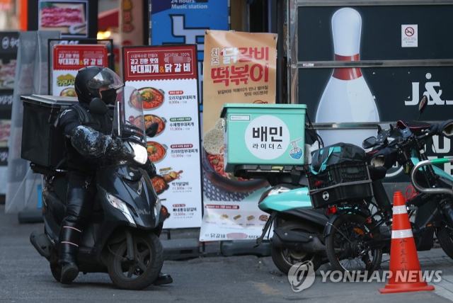 서울 시내 한 음식점 거리에서 배달 라이더가 오토바이를 주차하고 있다. 연합뉴스
