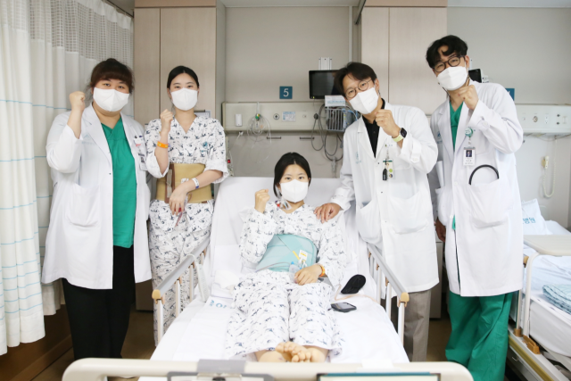 다낭성 신증후군 환자 이가영(가운데)씨가 로봇을 이용한 신장이식 수술을 성공적으로 마친 후 의료진과 기념촬영을 하고 있다. 사진 제공=서울아산병원