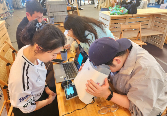 대웅제약 부스 방문객이 위스키와 옵티나를 활용해 안저 상태를 확인하고 있다. 사진 제공=대웅제약