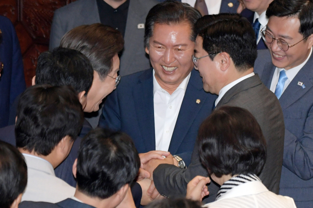 이재명 대통령이 26일 서울 여의도 국회에서 열린 본회의에서 2025년도 제2회 추가경정예산안에 대한 정부의 시정연설을 마치고 회의장을 나서며 더불어민주당 당대표에 출마한 정청래· 박찬대 의원과 손을 잡고 있다. 성형주 기자