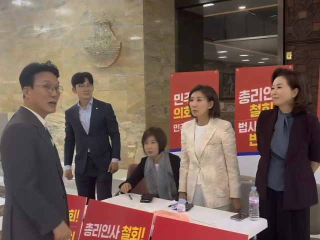 김민석 국무총리 후보자(맨 왼쪽)가 30일 오후 서울 여의도 국회 로텐더홀에서 농성 중인 나경원 국민의힘 의원(왼쪽 네 번째)과 대화를 나누고 있다. 뉴스1