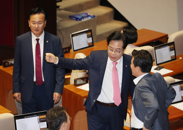 4일 국회 본회의장에서 국민의힘 송언석 비상대책위원장 겸 원내대표가 우원식 국회의장과 본회의 개의 지연 관련 이야기를 나눈 뒤 자리로 향하며 의원들과 대화하고 있다. 연합뉴스