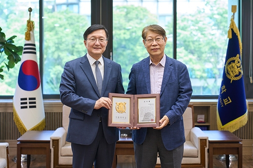 유홍임(왼쪽) 서울대 총장이 지난달 27일 서울대에 기금 2억 원을 기부한 김진오 로봇앤드디자인 회장에게 감사패를 전달하고 있다. 사진 제공=서울대