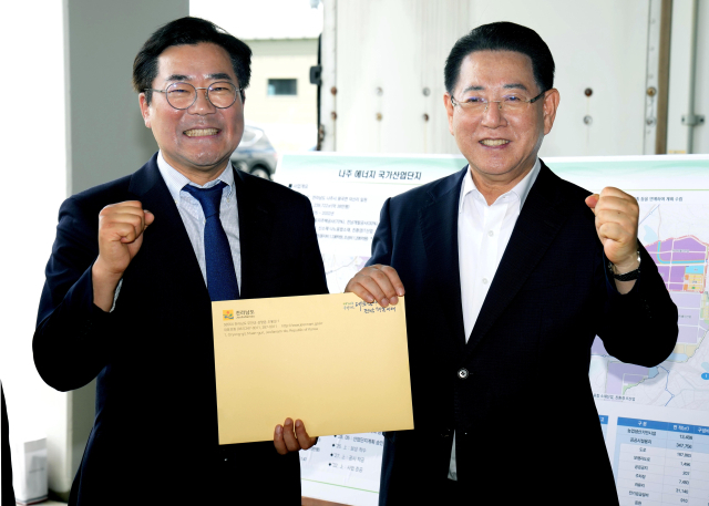 김영록 전라남도지사가 지난 6일 나주 에너지국가산단 조성 현장을 방문한 박찬대 더불어민주당 국회의원에게 전남도 현안 해결을 위한 건의 및 협조를 요청한 뒤 파이팅을 외치고 있다. 사진 제공=전라남도