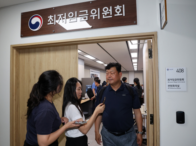 최저임금위원회 근로자위원인 류기섭 한국노총 사무총장이 9일 새벽 정부세종청사에서 전날에 이어 차수를 변경해 열린 제11차 전원회의를 마친 뒤 나오며 기자들의 질문에 답하고 있다. 연합뉴스