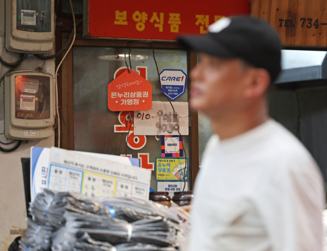 정부가 민생회복 소비쿠폰 1차 지급계획을 발표한 6일 서울의 한 전통시장 점포에 기존 골목경제 소비 활성화를 위한 온누리상품권 가맹 팻말이 붙어 있다. 경기 진작을 위한 이재명 정부의 첫 민생회복 소비쿠폰 신청과 지급이 이달 21일부터 9월 12일까지 8주간 이뤄진다. 연합뉴스