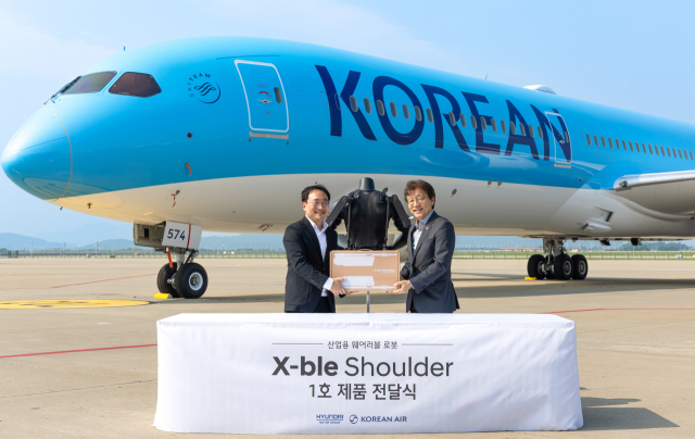 현동진(왼쪽) 현대차·기아 로보틱스랩 상무와 정현보 대한항공 항공우주사업본부 상무가 8일 인천시 중구 대한항공 항공기 정비고에서 진행된 ‘엑스블 숄더 1호 전달식’에서 기념 촬영을 하고 있다. 사진 제공=현대차·기아