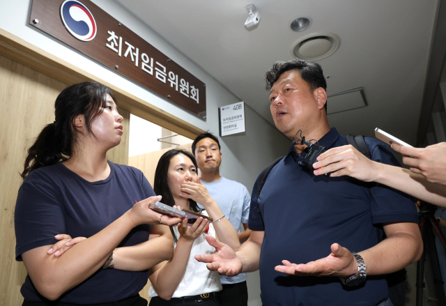 최저임금위원회 근로자위원인 류기섭 한국노총 사무총장이 9일 새벽 정부세종청사에서 전날에 이어 차수를 변경해 열린 제11차 전원회의를 마친 뒤 나오며 기자들의 질문에 답하고 있다. 연합뉴스