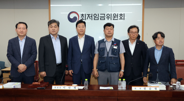 10일 정부세종청사에서 열린 제12차 전원회의에서 내년 최저임금을 시간당 1만320원으로 17년만에 합의로 결정한 공익위원-사용자위원-근로자위원들이 기념 촬영을 하고 있다. 왼쪽부터 하헌제 상임위원, 이인재 위원장, 사용자위원인 류기정 한국경영자총협회 전무, 근로자위원인 류기섭 한국노총 사무총장, 사용자위원인 이명로 중소기업중앙회 인력정책본부장, 공익위원인 권순원 숙명여대 교수. 연합뉴스