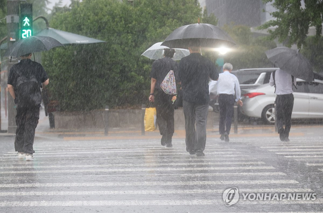 서울 서남권에 호우주의보가 발효된 8일 서울 영등포구 여의도 국회 인근에서 시민들이 우산을 쓰고 횡단보도를 건너고 있다. 연합뉴스