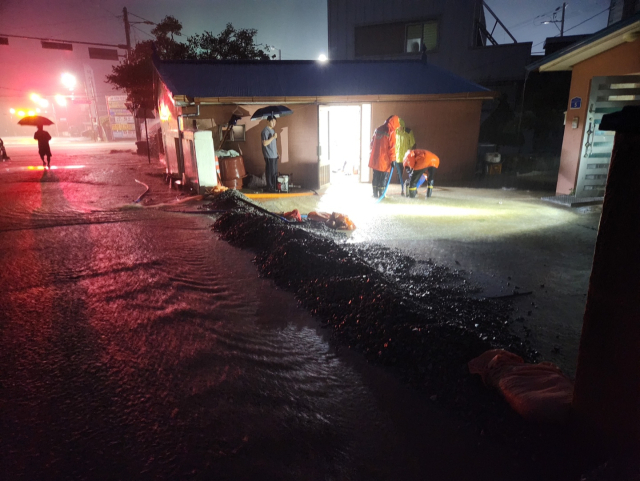 충남 전역에 호우특보가 발효된 가운데 17일 오전 3시51분께 예산군 덕산면에서 주택이 침수돼 소방당국이 안전조치를 하고 있다. 연합뉴스