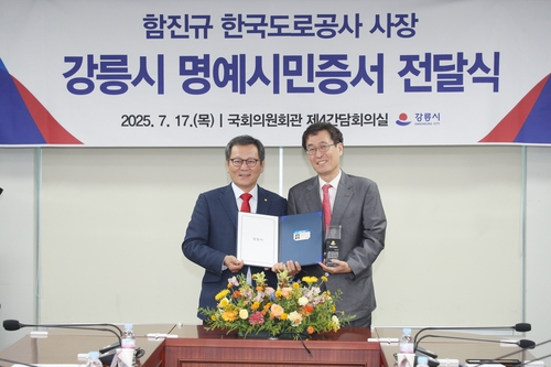 김홍규(왼쪽) 강릉시장이 17일 국회의원회관에서 함진규 한국도로공사 사장에게 명예시민증을 전달하고 있다. 사진 제공=강릉시