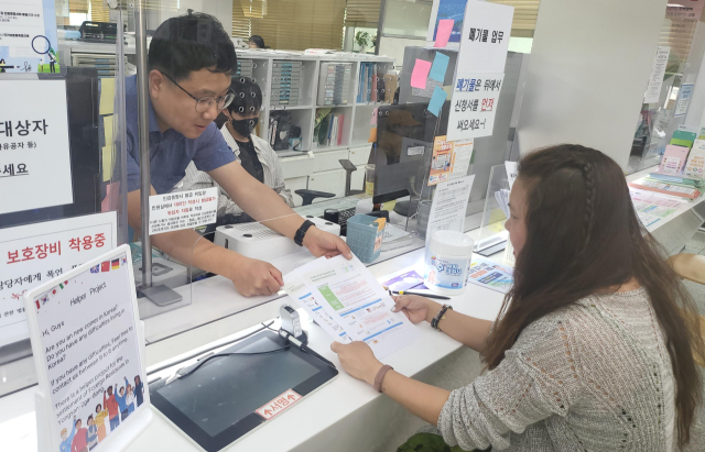 용산2가동주민센터 직원이 외국인 전입자에게 외국어 생활정보 안내문을 전달하고 있다. 사진 제공=용산구