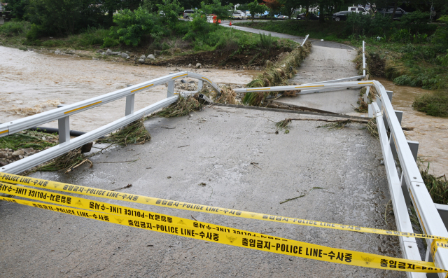 18일 충남 서산시 해미천의 한 교량이 전날 내린 폭우로 인해 빠른 유속과 수압, 부유물의 무게를 이기지 못한 채 붕괴돼 처참한 모습을 보이고 있다. 서산=오승현 기자