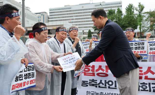 농축산 단체 회원들이 18일 한미 상호관세 협상 농축산물 개방 반대 건의문을 대통령실 관계자에게 전달하고 있다. 연합뉴스