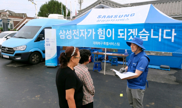 18일 충청남도 예산군 삽교읍에서 삼성전자서비스 엔지니어가 수해 복구 특별 점검 서비스를 실시하는 모습. 사진제공=삼성전자서비스