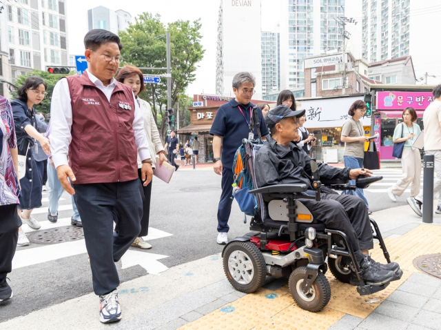 박강수 마포구청장(왼쪽)이 보행약자를 위해 조성한 무장애길을 장애인과 같이 가고 있다. 사진제공=마포구