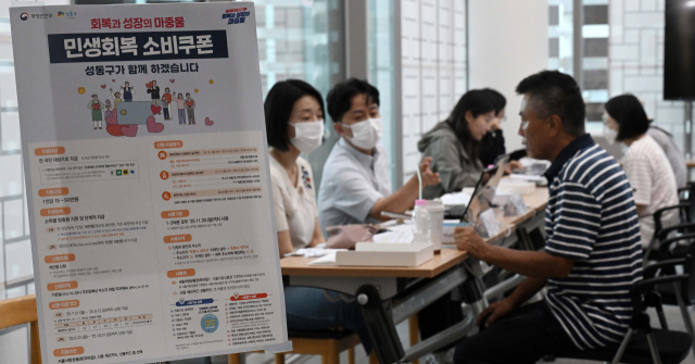 민생경제 회복을 위한 '민생회복 소비쿠폰' 신청이 시작된 21일 서울 성동구 옥수동 주민센터에 마련된 접수처에서 주민들이 소비쿠폰을 신청하고 있다. 조태형 기자 2025.07.21