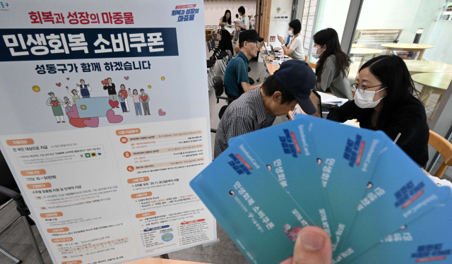 민생경제 획복을 위한 '민생회복 소비쿠폰' 신청이 시작된 21일 서울 성동구 옥수동 주민센터에 마련된 접수처에서 주민들이 소비쿠폰을 신청하고 있다. 조태형 기자 2025.07.21