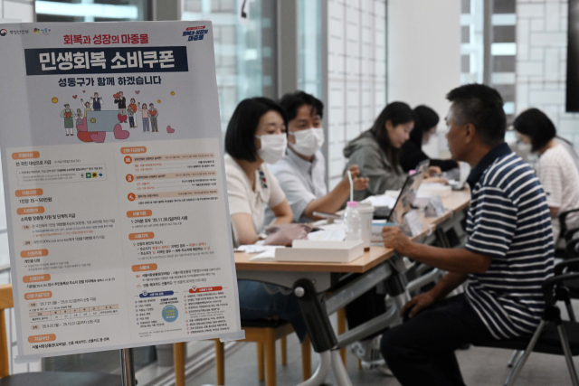 민생 경제 회복을 위한 ‘민생회복 소비쿠폰’ 신청이 시작된 21일 서울 성동구 옥수동 주민센터에 마련된 접수처에서 주민들이 소비쿠폰을 신청하고 있다. 조태형 기자 2025.07.21