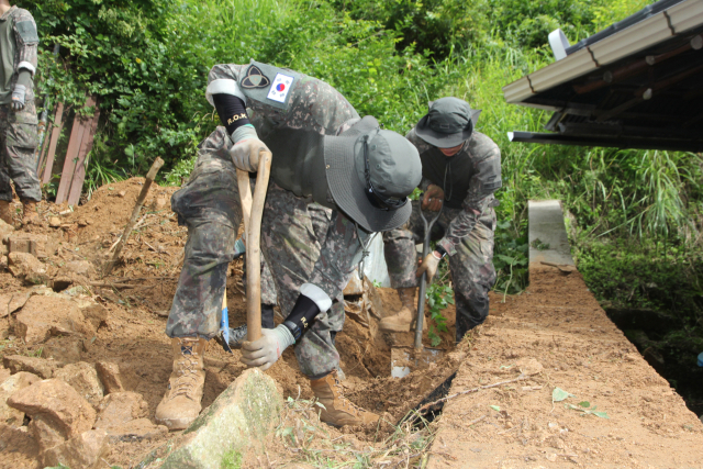 육군 제35보병사단 장병들이 21일 경남 전남 순창군 풍산면 침수 피해 민가 주변에 쌓인 토사를 제거하고 있다. 사진 제공=육군