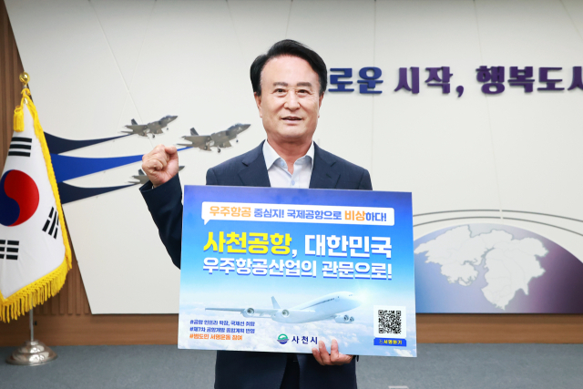 박동식 사천시장이 22일 사천공항의 국제공항 승격을 바라는 피켓을 들고 서명운동 홍보 캠페인을 알리고 있다. 사진 제공=사천시