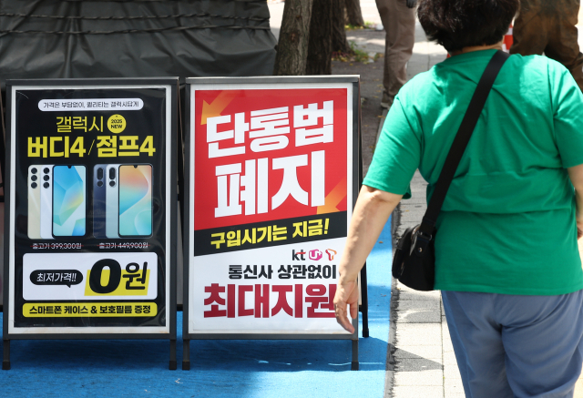 21일 서울의 한 휴대폰 판매점 앞에 ‘단통법 폐지’라고 적힌 안내판이 놓여 있다. 연합뉴스
