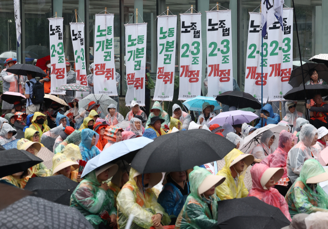 민주노총이 16일 서울 영등포구 국회 인근에서 연 수도권 총파업 대회에서 참가자들이 손팻말을 들고 있다. 연합뉴스